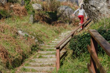 Kız doğal parktaki merdivenlerden tırmanıyor