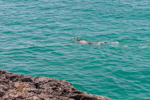 スキューバ ダイビングのマスクの男は 青い海の水で泳ぐ — ストック写真