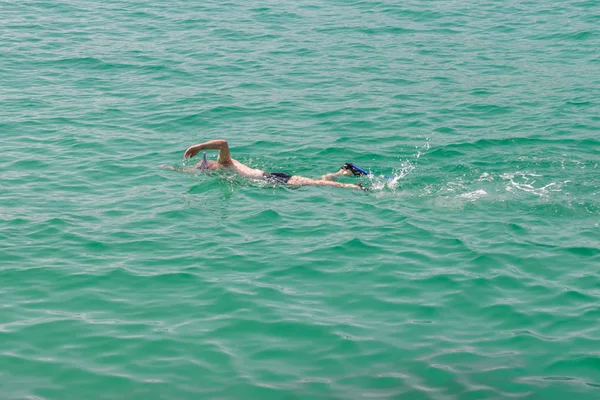 スキューバ ダイビングのマスクの男は 青い海の水で泳ぐ — ストック写真