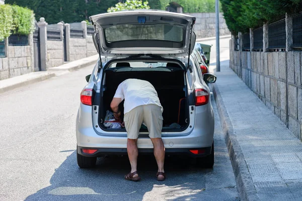 Άνθρωπος Βάζει Πράγματα Στο Πορτ Μπαγκάζ Ενός Αυτοκινήτου — Φωτογραφία Αρχείου