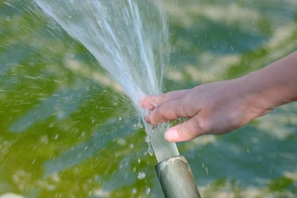 Vrouwelijke Hand Raakt Het Water Uit Pipe — Stockfoto