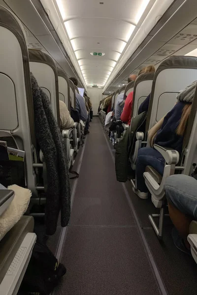 Vista trasera de las personas en un avión de pasajeros —  Fotos de Stock