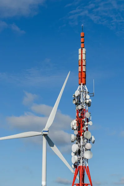 Cellulaire antennes en windturbine tegen een blauwe hemel — Stockfoto