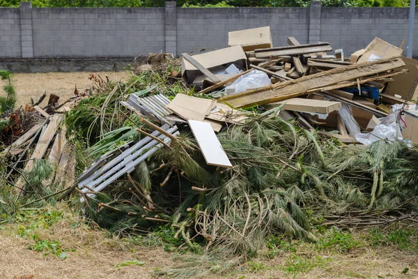 Gałęzie drzew ciętych, tektura, opakowania plastikowe w wysypisko miasta — Zdjęcie stockowe