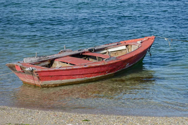 Червоний дерев'яний рибальський човен причалив на березі — стокове фото
