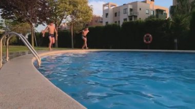 mutlu çocuklar havuzun mavi suya atlama, yavaş hareket