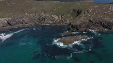 deniz dalgaları kayalık bir kıyıya çarpıyor, drone en üst görünümü 4k