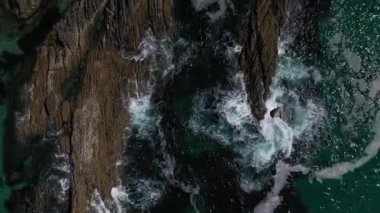 deniz dalgaları drone kayalık bir kıyı üst görünümüne karşı çökmesini