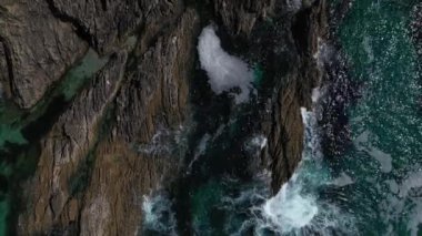 deniz dalgaları drone kayalık bir kıyı üst görünümüne karşı çökmesini