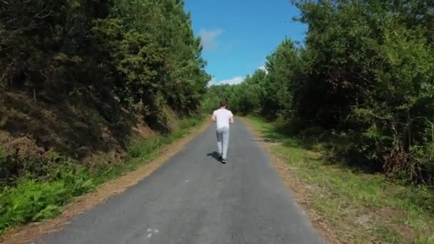 Jovem Correndo Estrada Floresta — Vídeo de Stock