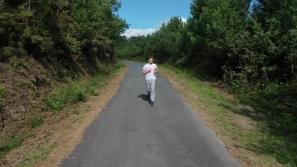 Jovem Correndo Estrada Floresta — Vídeo de Stock