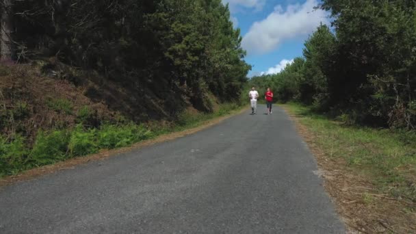 Jovem Casal Correndo Estrada Floresta — Vídeo de Stock