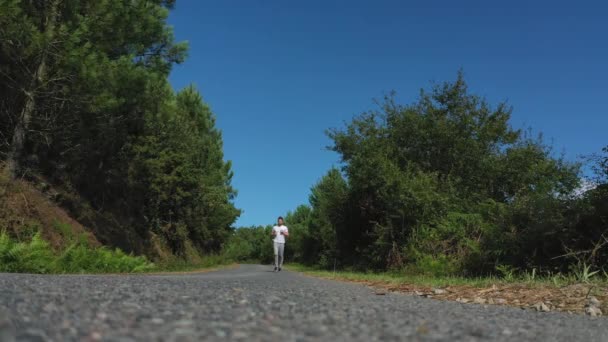 Jovem Correndo Estrada Floresta — Vídeo de Stock