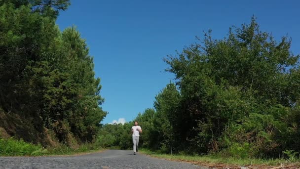 Jovem Correndo Estrada Floresta — Vídeo de Stock