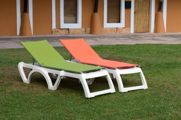 Chaises longues d'été en plastique dans le jardin de la maison — Photo