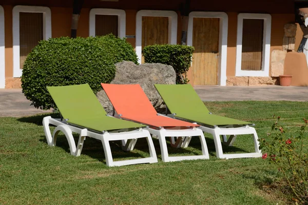 Chaises longues d'été en plastique dans le jardin de la maison — Photo