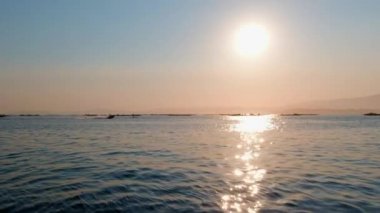 İnsanlar gün batımına karşı denizde jet ski kullanıyorlar.