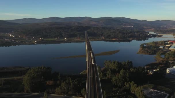 火车过桥过河顶部的景色被夕阳西下的无人驾驶飞机射中 — 图库视频影像