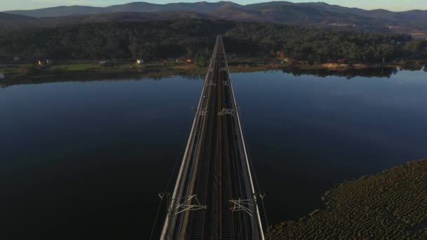 空中俯瞰横跨河流的桥顶部俯瞰夕阳西下的无人驾驶飞机 无人驾驶飞机低空飞越桥 — 图库视频影像