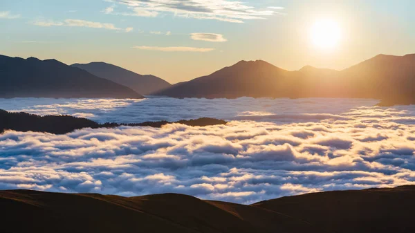 Sunrise in the mountains. Clouds between mountains down in a mountain valley — Stock Photo, Image