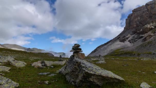 Mouvement temporel. Pyramide de pierre sur un sentier de randonnée dans les montagnes, vol gonflé nuages blancs gonflés dans le ciel bleu vif — Video