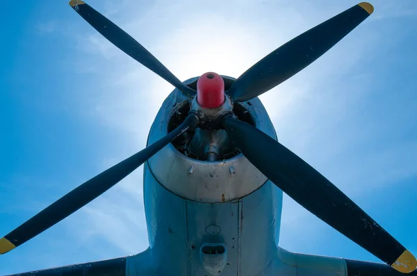 Closeup photo of plane propeller with blue sky on the background.