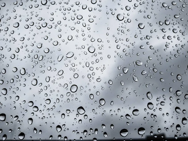 Gocce di pioggia sul vetro di un'auto, concentrati sulle gocce di pioggia. Finestra sfocata . — Foto Stock