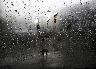 Arabanın camına yağmur damlaları, yağmur damlaları odaklanın. Bulanık pencere ve el izi.