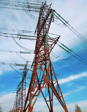 Kentsel alanda yüksek elektrik direkleri var. Enerji arzı, enerji dağılımı, enerji iletimi, enerji iletimi, yüksek voltaj arzı konsepti fotoğrafı.