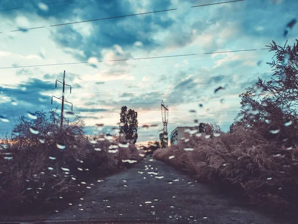Gocce di pioggia sul vetro di un'auto, concentrati sul cielo. Finestra offuscata. Gocce al tramonto . — Foto Stock