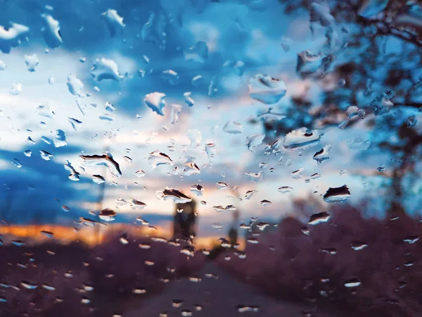 Gocce di pioggia sul vetro di un'auto, concentrati sulle gocce di pioggia. Finestra offuscata. Gocce al tramonto . — Foto Stock