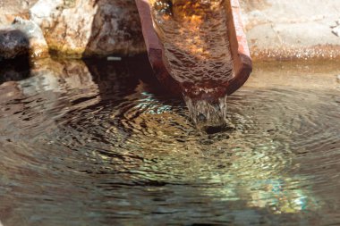 Pis su borusu küçük bir dere dökülen su