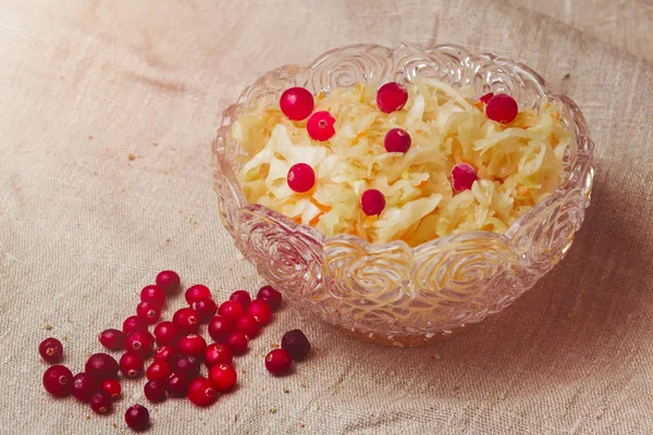 Sauerkraut en un plato y arándanos sobre un fondo de saco — Foto de Stock