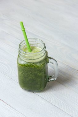 Beyaz ahşap zemin üzerinde sağlıklı yeşil smoothie