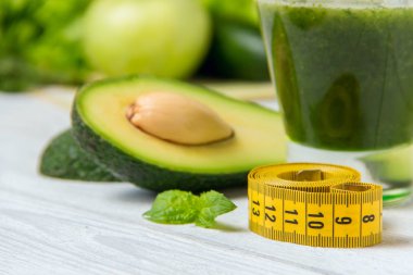 Beyaz ahşap zemin üzerinde malzemelerle sağlıklı yeşil smoothie