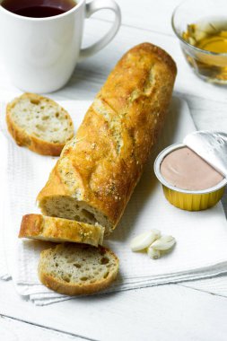 Sarımsak baget pate ahşap masa üzerinde beyaz mutfak havlu üzerinde.