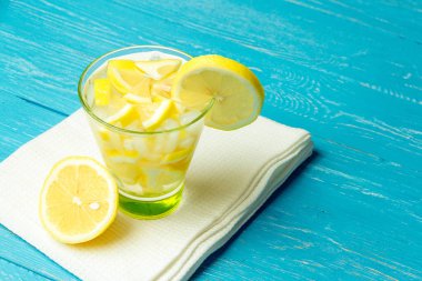 Limonlu su. Mavi ahşap zemin üzerine limon dilimleri ile limonata.