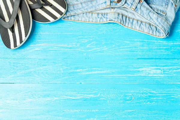 Πλαίσιο κομψό παντόφλες τζιν σε μπλε φόντο ξύλινη, copyspace για το κείμενο, καλοκαιρινές διακοπές. — Φωτογραφία Αρχείου