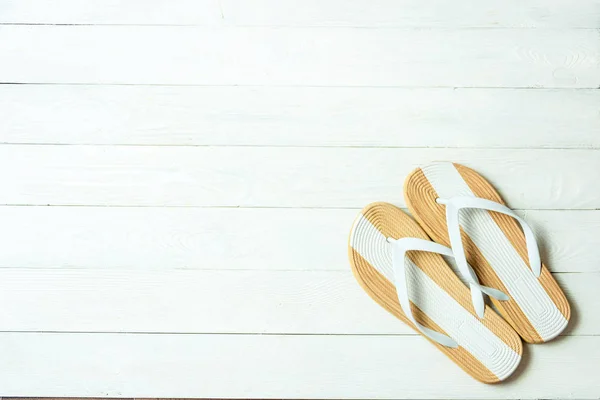 Cadre élégant pantoufles féminines sur fond blanc en bois, copyspace pour le texte, vacances d'été . — Photo