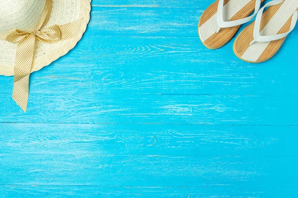 Çerçeve zarif kadın hasır şapka terlik boşaltmak için metin, mavi ahşap arka plan üzerinde tatil yaz. — Stok fotoğraf