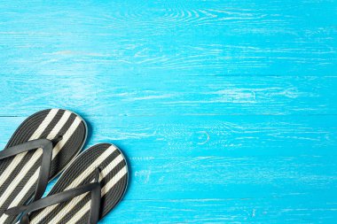 Çerçeve zarif kadın terlik boşaltmak için metin, mavi ahşap arka plan üzerinde tatil yaz.