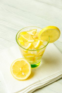 Limonlu su. Beyaz ahşap zemin üzerine limon dilimleri ile limonata.