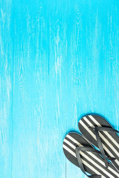 Moldura elegante chinelos femininos em fundo de madeira azul, espaço para texto, férias de verão . — Fotografia de Stock