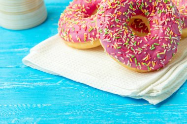 Çörek bir mutfak havlusu ve mavi ahşap masa. Tatlılar boşaltmak ile fotoğraf.