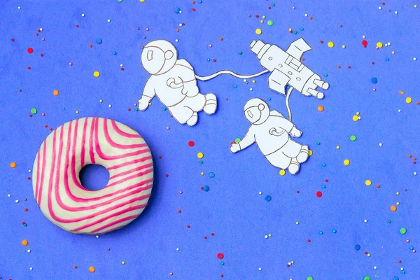 Yaratıcı yiyecekler minimalizm, astronot, uzay gemisi üstten görünüm, kopya alanı ile mavi gökyüzünde gezegenin şeklinde çörek.