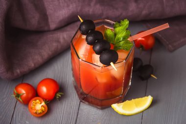 Gri ahşap masa üzerinde gözlük buz ile Kokteyl Bloody Mary.
