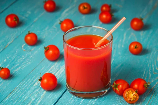 Jugo de tomate en vasos sobre mesa de madera azul . — Foto de Stock