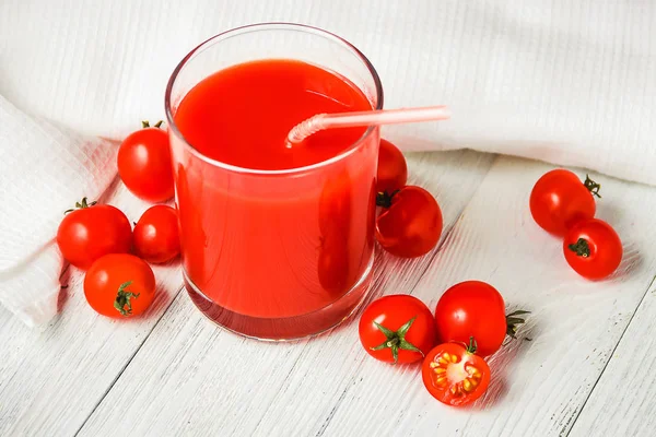 Jugo de tomate en vasos sobre mesa de madera blanca . — Foto de Stock