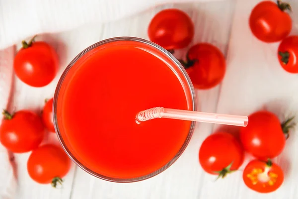 Beyaz ahşap masa üzerinde gözlük domates suyu. üst görünüm. — Stok fotoğraf