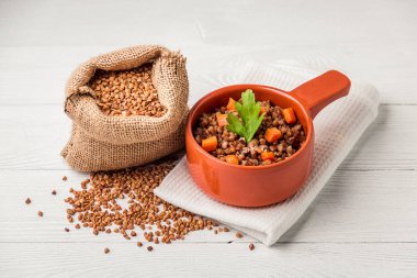 Beyaz ahşap masa üzerinde lezzetli karabuğday lapası Kahverengi kase.